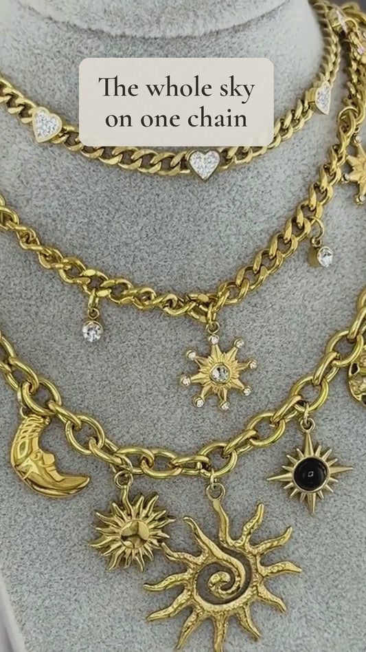 Shams gold necklace with sun, crescent and star charms shown up close