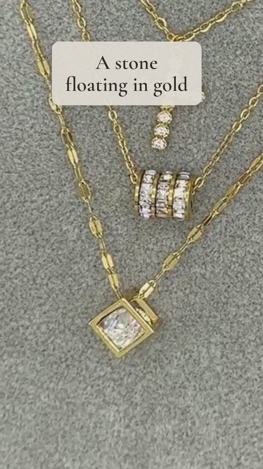 Roshni necklace with a brilliant stone floating inside an open gold cube pendant